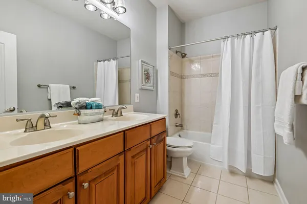 a bathroom with a double vanity sink toilet and shower