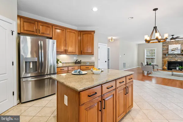 a kitchen with stainless steel appliances granite countertop a refrigerator a sink and a stove
