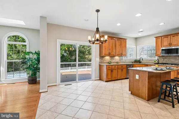a kitchen with stainless steel appliances granite countertop a refrigerator a sink a stove top oven and a large window