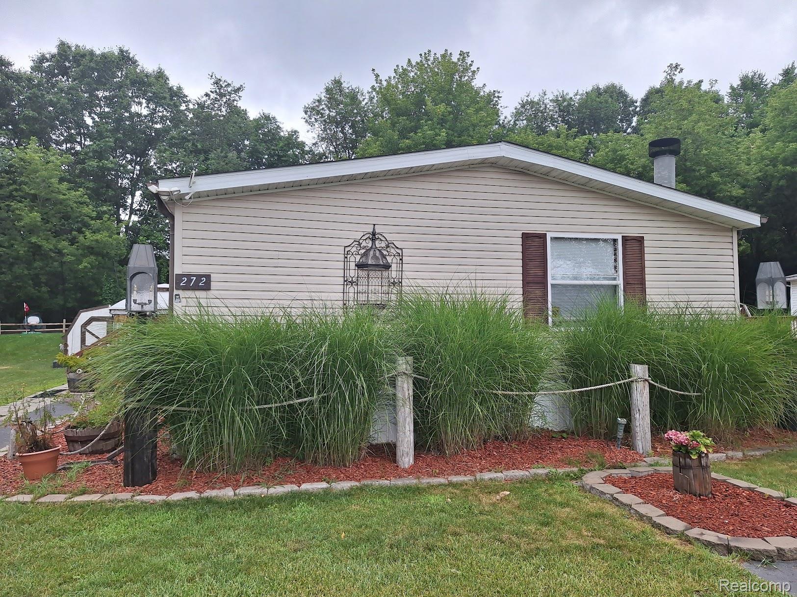 2500-mann Rd Mann Road Clarkston, MI 48346 - Photo 1 of 22 Beige horizontal siding exterior with a dark brown front door and coordinating window shutters