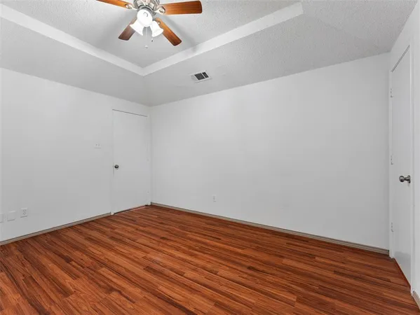 a view of room with wooden floor and fan