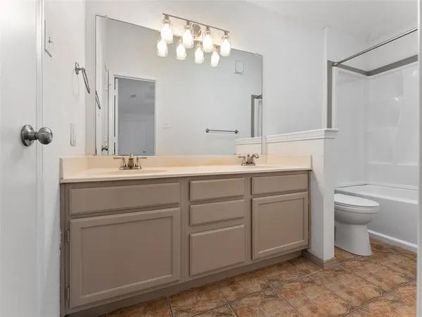 a bathroom with a double vanity sink a toilet and a mirror