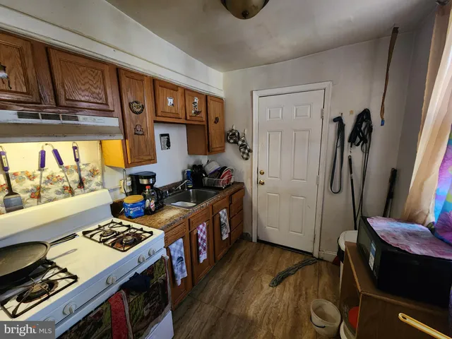 a kitchen that has a stove and a wooden floor