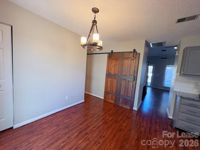 a view of a room with wooden floor staircase and a kitchen
