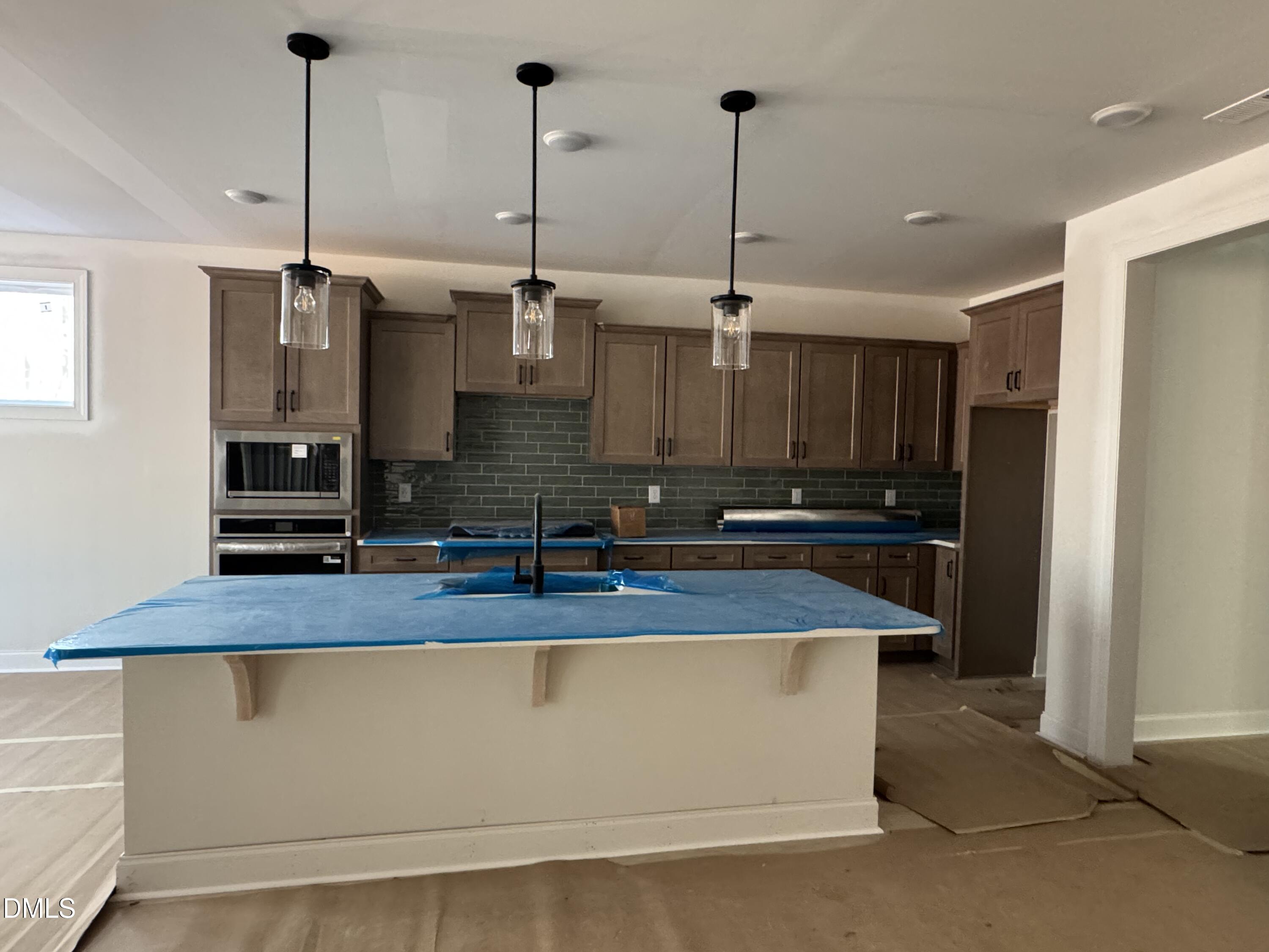 134 West Victoria Rdg Drive, Unit 22 Selma, NC 27576 - Photo 4 of 18 a kitchen with kitchen island granite countertop a sink a counter space and stainless steel appliances