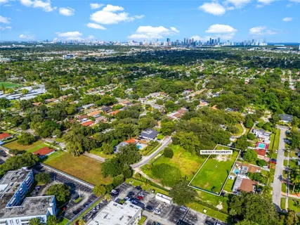 an aerial view of residential houses with outdoor space and trees