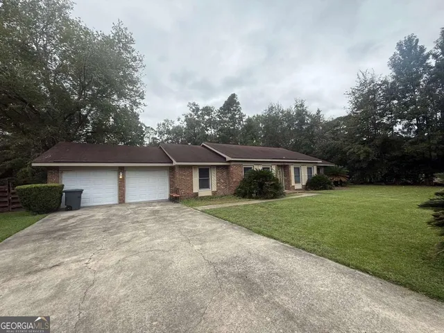a front view of a house with a yard and trees