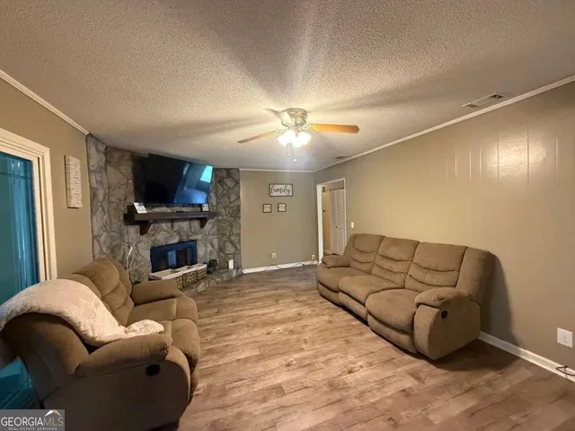 a living room with furniture a fireplace and a flat screen tv