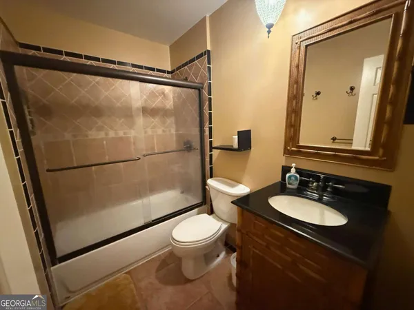 a bathroom with a sink a toilet a mirror and shower
