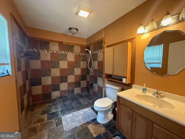 a bathroom with a sink toilet and shower