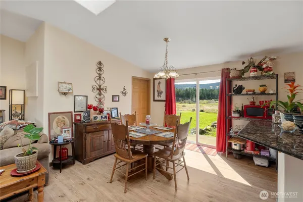 a view of a dining room and livingroom with furniture wooden floor a chandelier