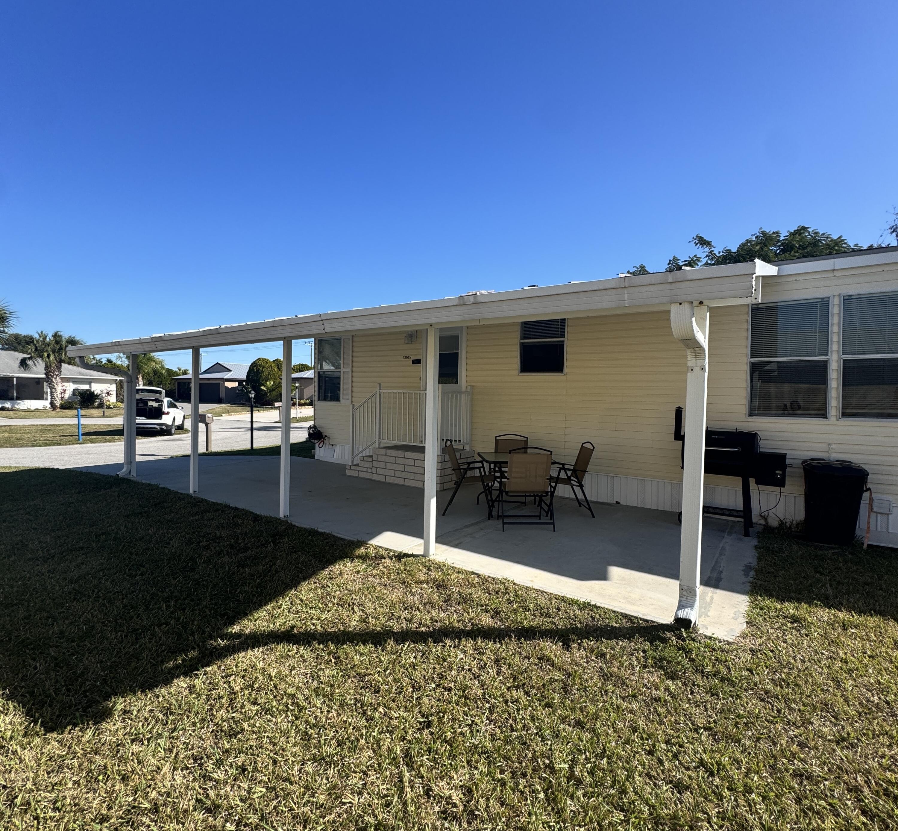 13965 Garza Court Fort Pierce, FL 34951 - Photo 12 of 44 a backyard of a house with table and chairs
