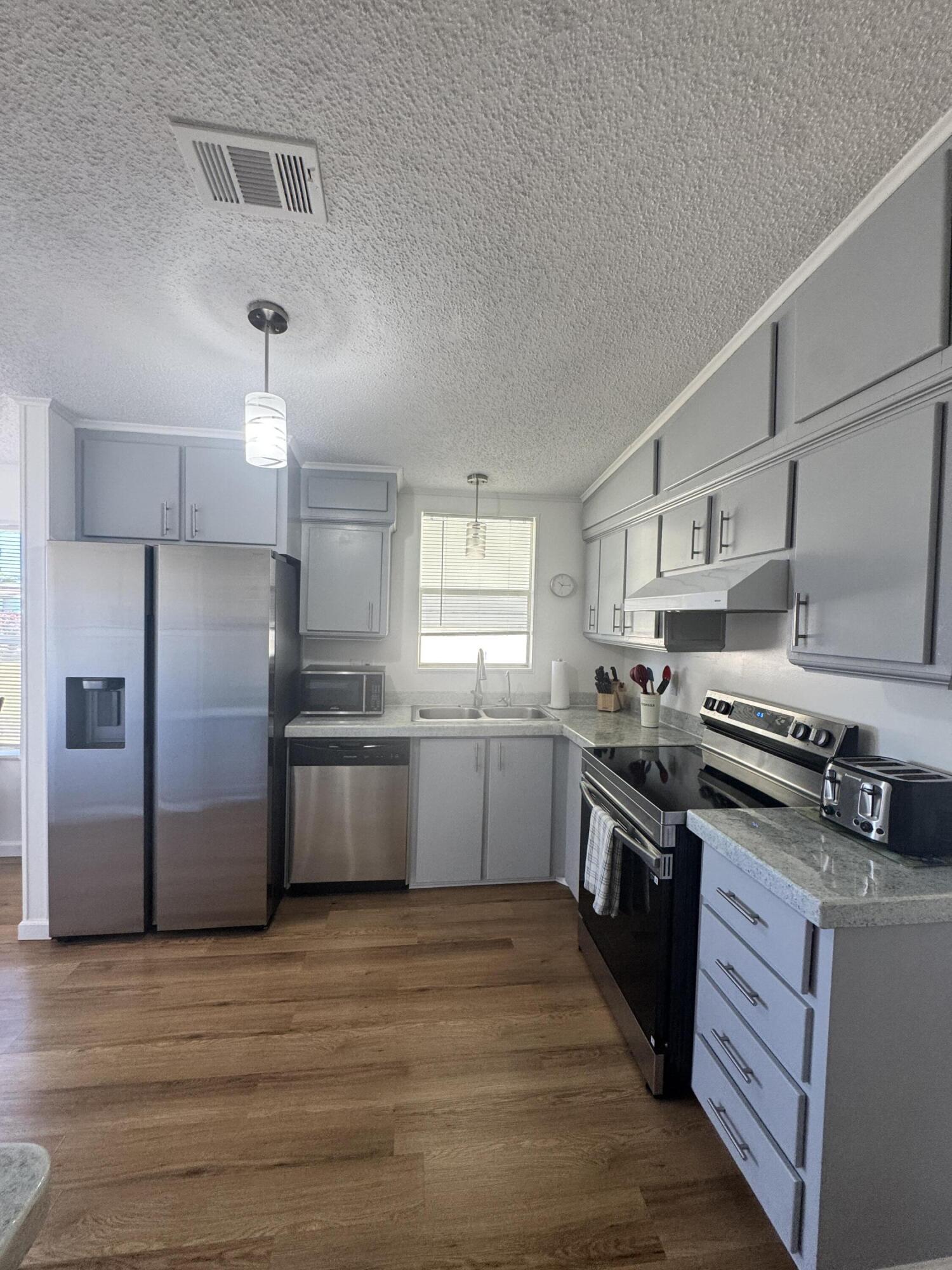 13965 Garza Court Fort Pierce, FL 34951 - Photo 14 of 44 a kitchen with stainless steel appliances granite countertop a stove and a refrigerator