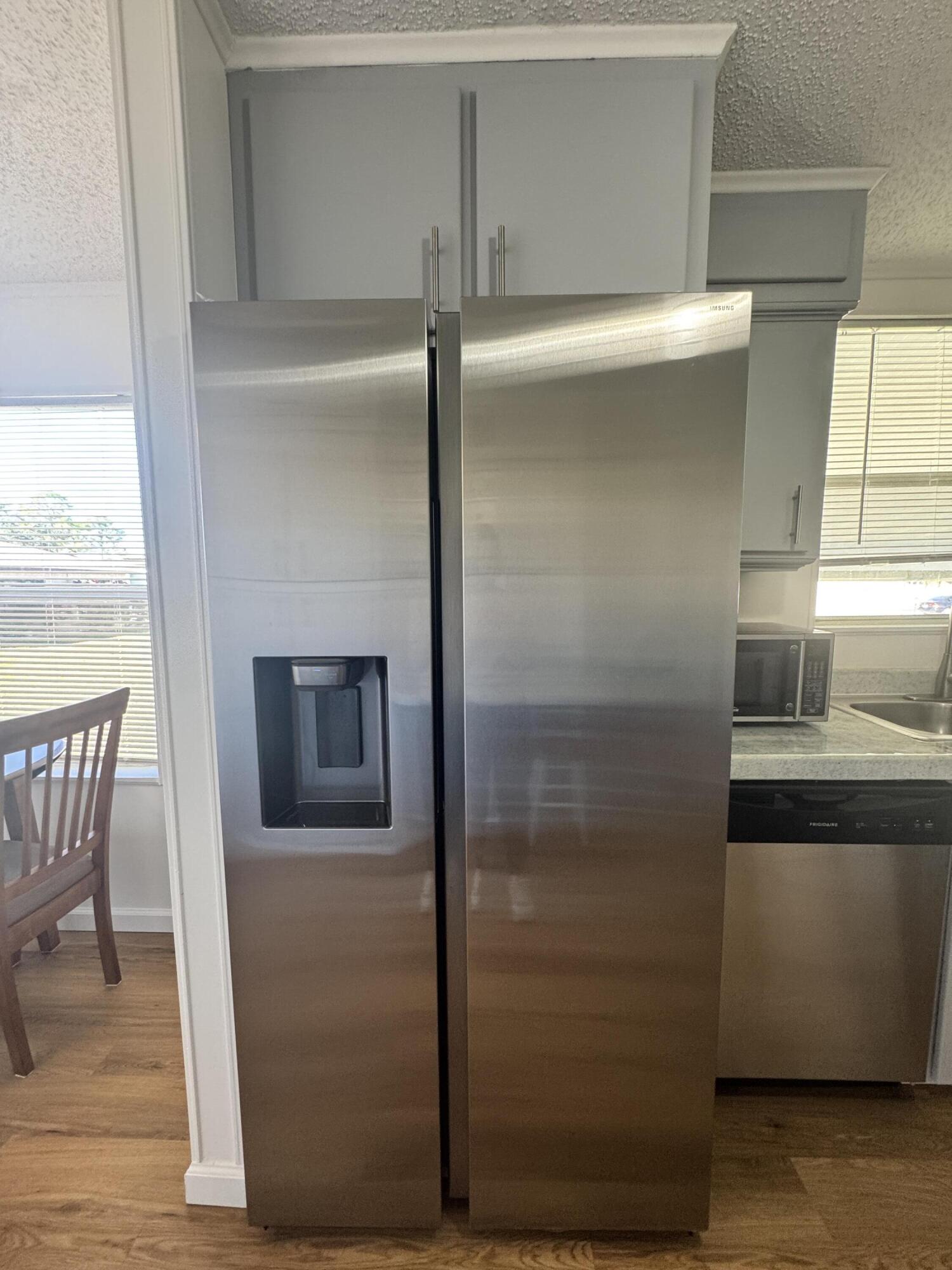 13965 Garza Court Fort Pierce, FL 34951 - Photo 17 of 44 a kitchen with a refrigerator and wooden cabinets