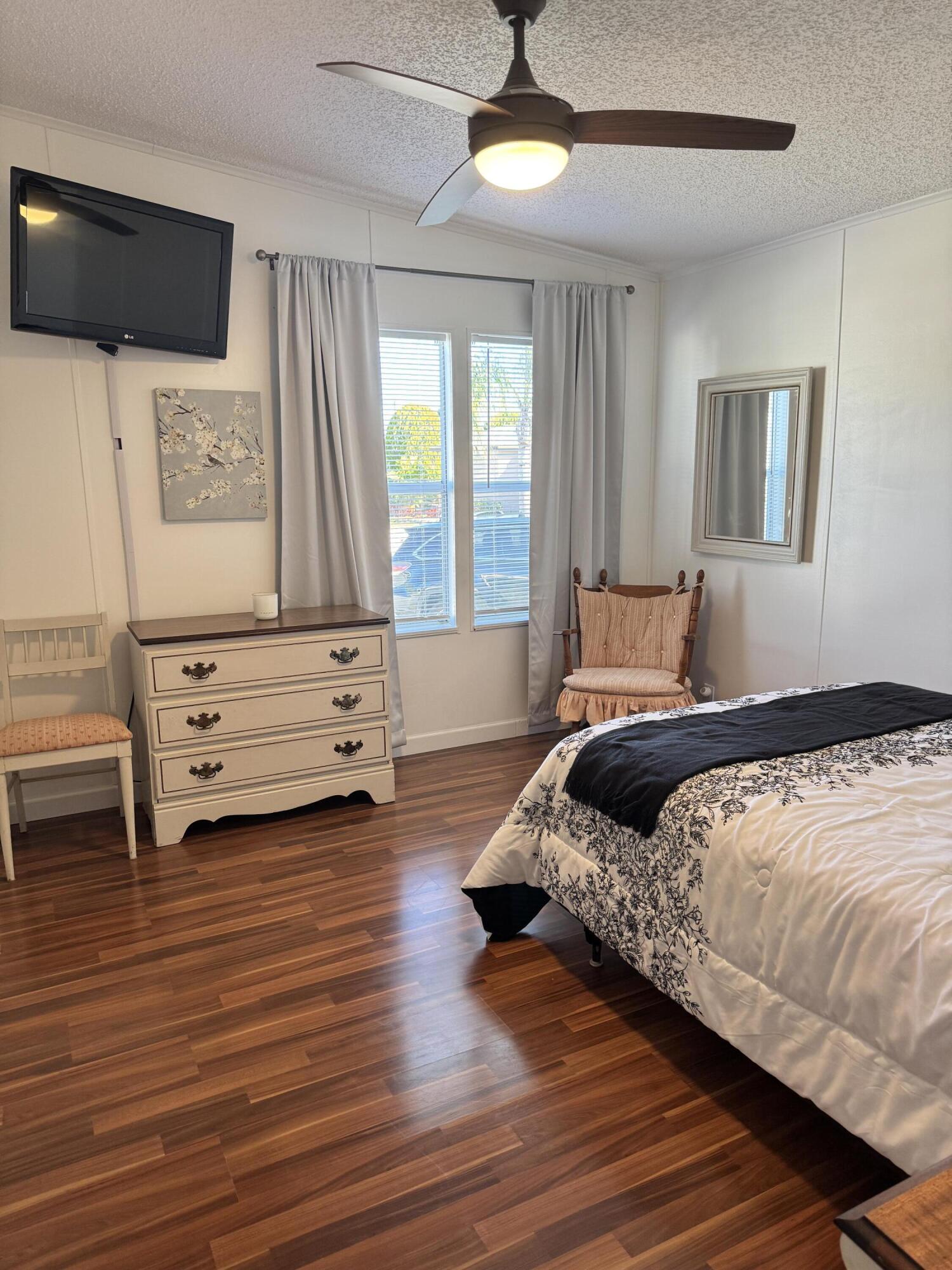 13965 Garza Court Fort Pierce, FL 34951 - Photo 36 of 44 a bedroom with a bed a flat screen tv and a large window