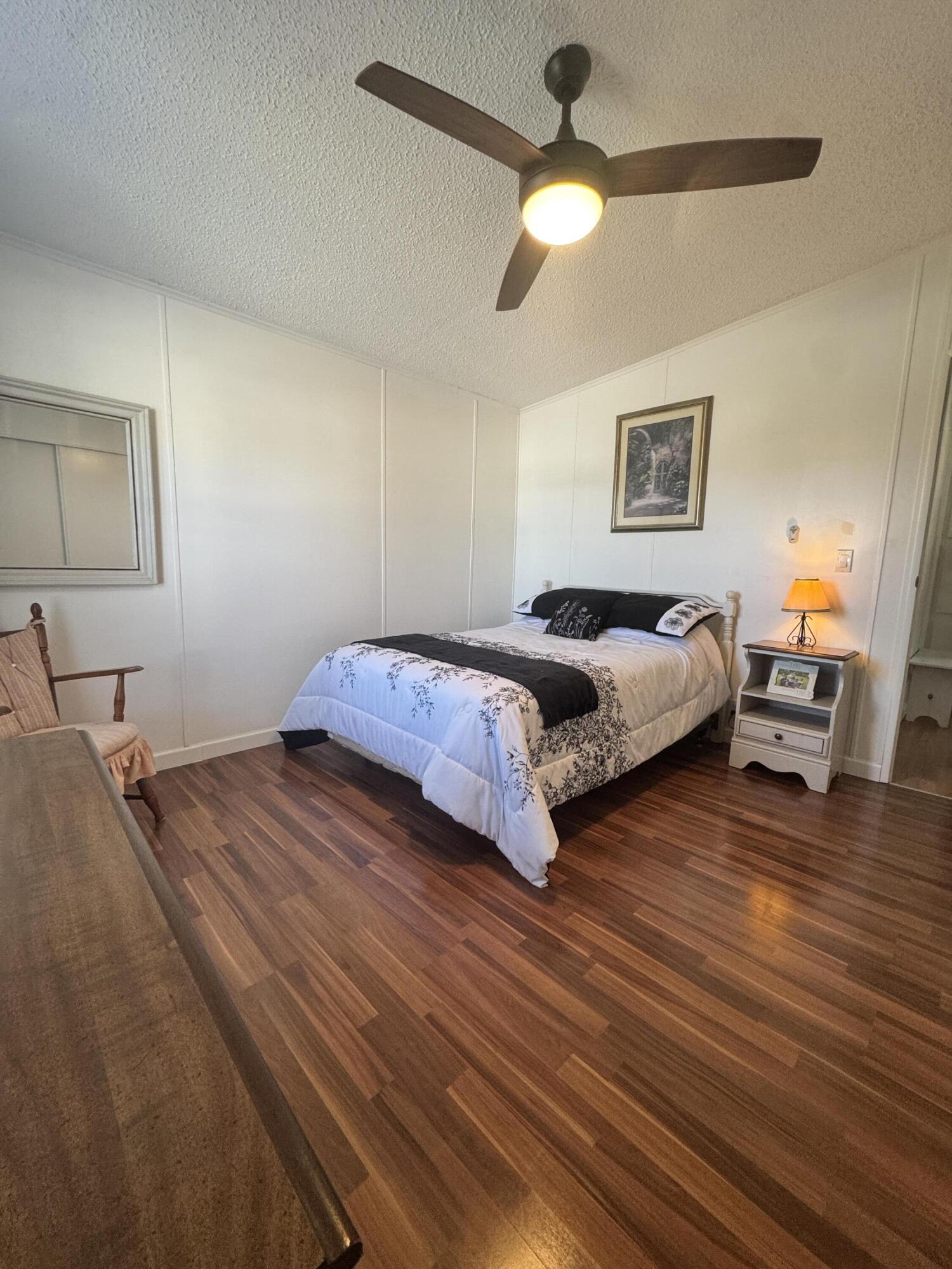 13965 Garza Court Fort Pierce, FL 34951 - Photo 37 of 44 a spacious bedroom with a bed and a chandelier