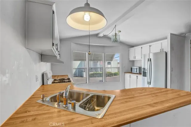 a kitchen with stainless steel appliances granite countertop a sink a refrigerator and a stove