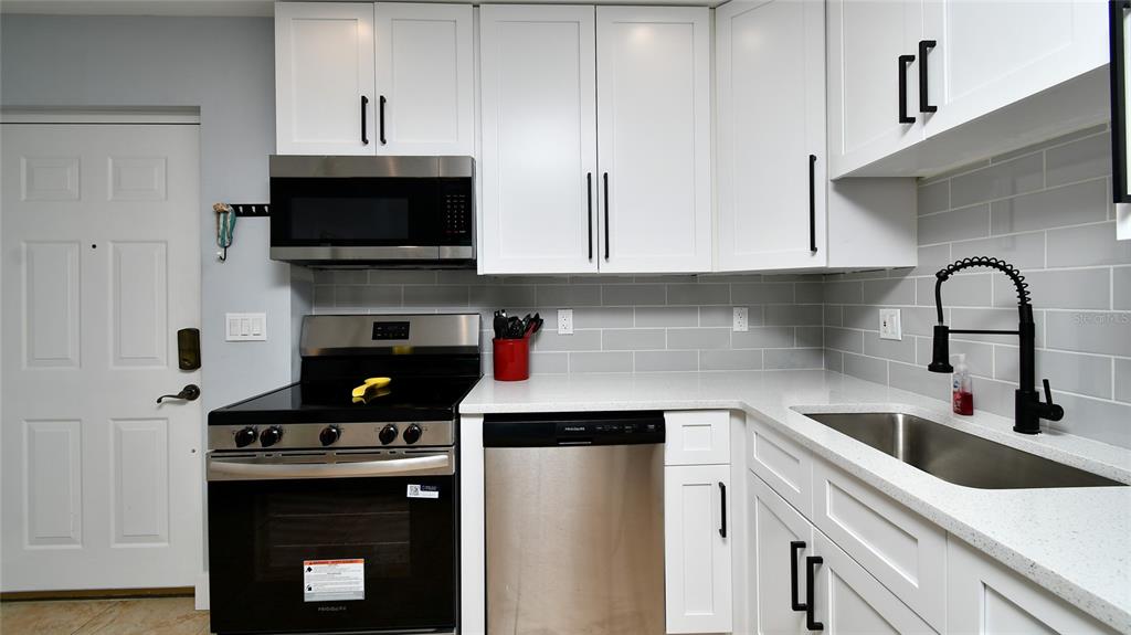 2090 Matecumbe Key Road, Unit 1308 Punta Gorda, FL 33955 - Photo 6 of 29 a kitchen with stainless steel appliances granite countertop a sink a stove and a microwave