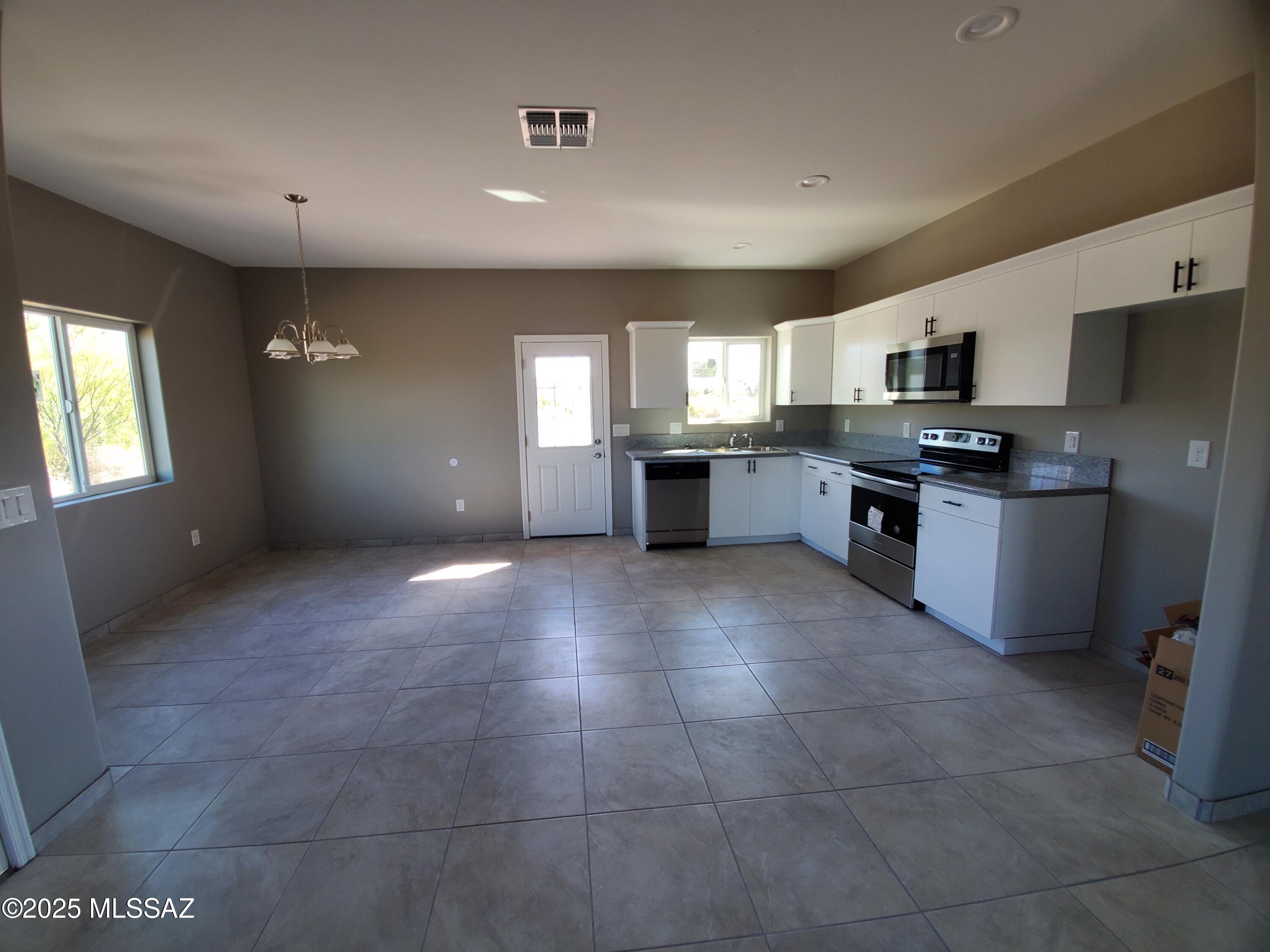 1885 Via Ochoa Rio Rico, AZ 85648 - Photo 2 of 11 a large kitchen with granite countertop a stove a sink dishwasher and a refrigerator