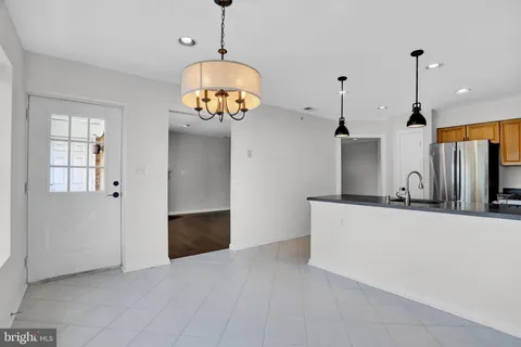 a view of a kitchen with a sink wooden floor and chandelier