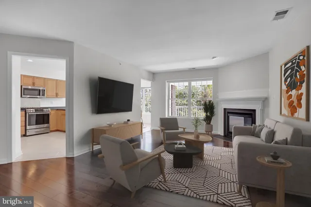 a living room with furniture a flat screen tv and a fireplace