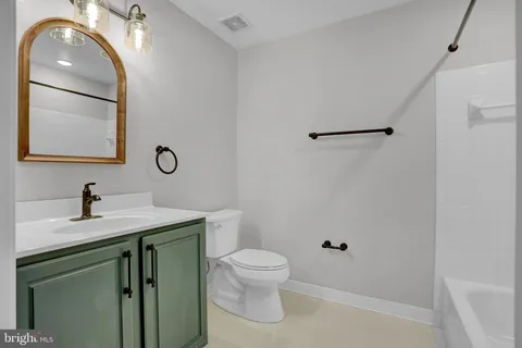 a bathroom with a toilet a sink and mirror