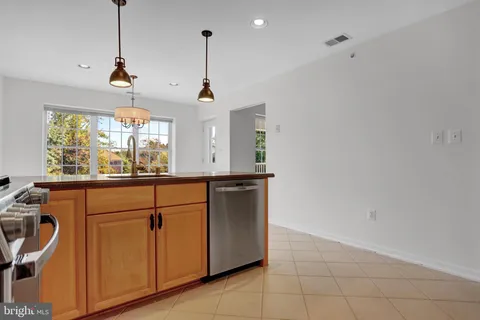 a kitchen with stainless steel appliances granite countertop a sink a window and a counter top space