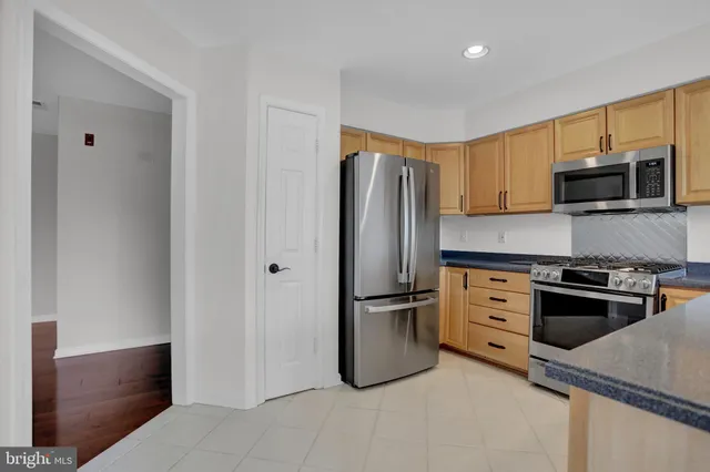 a kitchen with stainless steel appliances granite countertop a refrigerator stove and microwave
