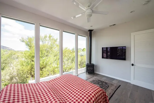 a bedroom with a large bed and a flat tv screen on dresser