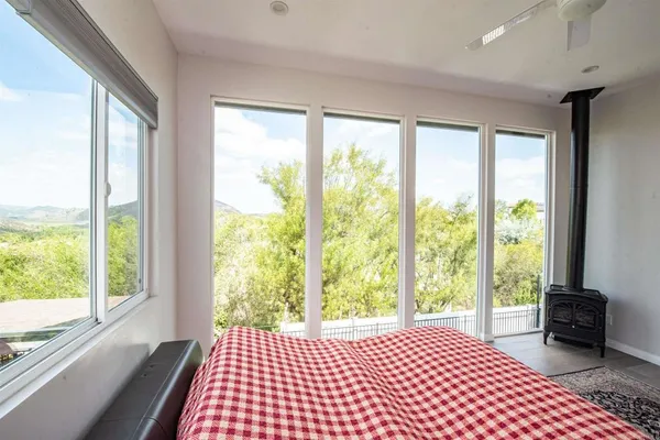 a bedroom with a bed and a large window