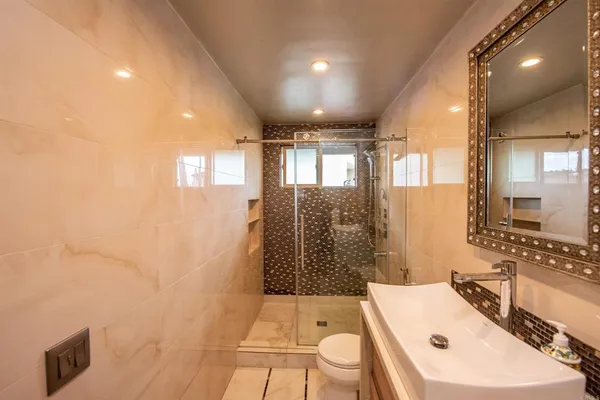 a bathroom with a sink a toilet and shower
