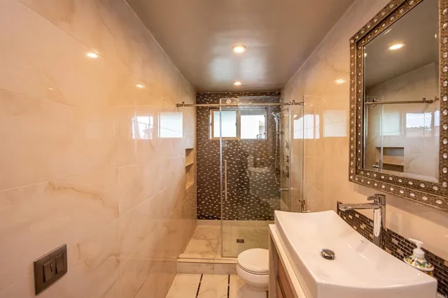 a bathroom with a sink a toilet and shower