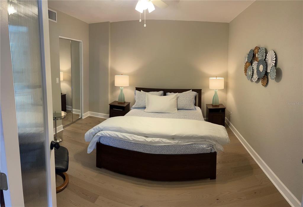 4651 South Atlantic Avenue, Unit 9105 Ponce Inlet, FL 32127 - Photo 10 of 20 a spacious bedroom with a bed and a chandelier