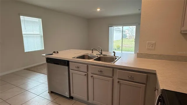 a view of a kitchen with a sink and a refrigerator