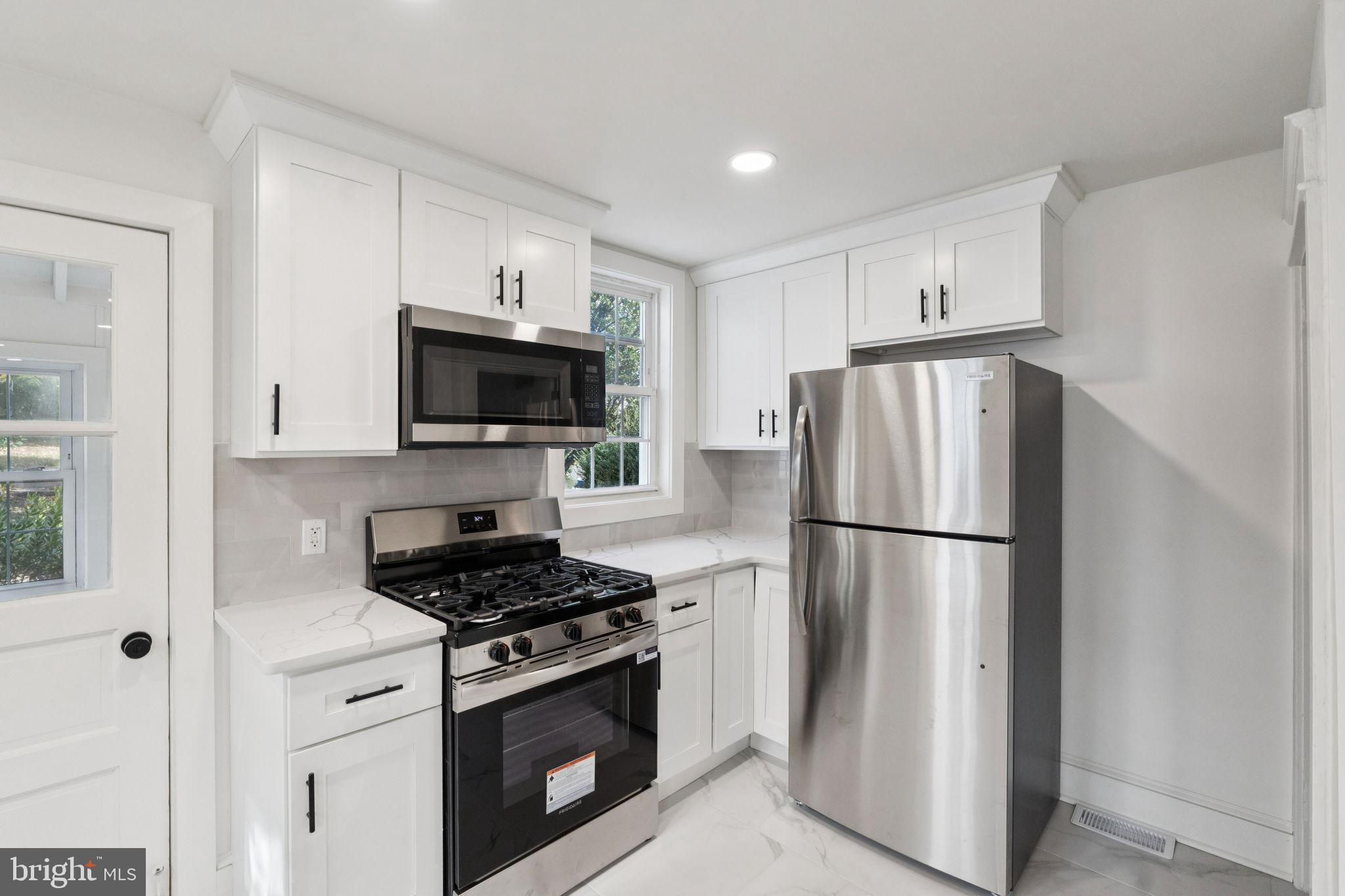 333 Blanchard Road Drexel Hill, PA 19026 - Photo 19 of 45 a kitchen with a stove a refrigerator and a microwave