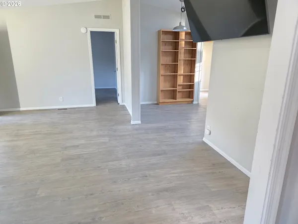 a kitchen with granite countertop a refrigerator a sink a stove a microwave and wooden floors