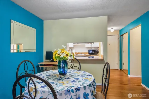 a dining room with furniture a potted plant and wooden floor