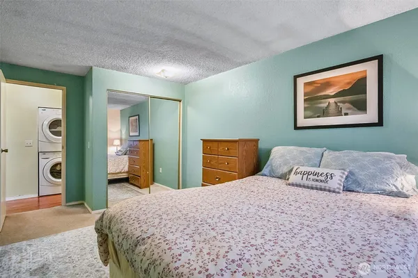 a bedroom with a bed and a painting on the wall