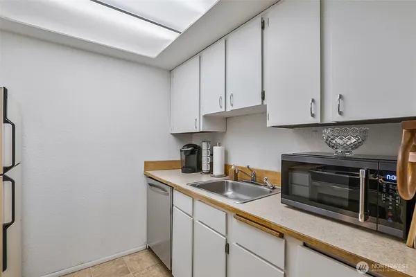 a kitchen with stainless steel appliances granite countertop a sink a stove and a microwave