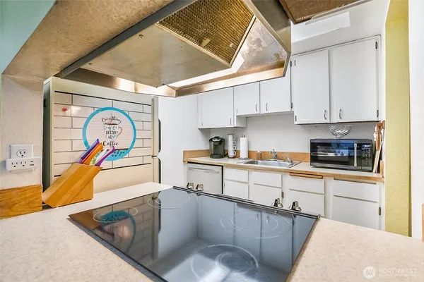 a kitchen with stainless steel appliances granite countertop a sink a stove and a microwave
