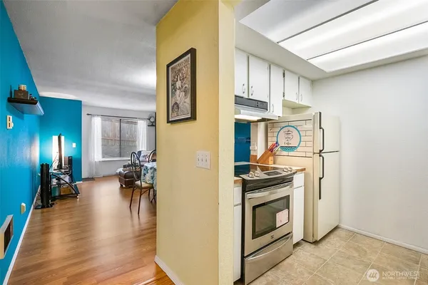 a view of a livingroom with furniture fridge and wooden floor