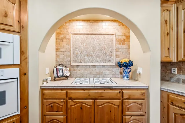a view of a kitchen with kitchen island granite countertop a stove and a wooden floors