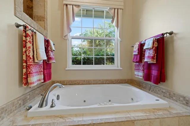 a bathroom with a tub sink and mirror