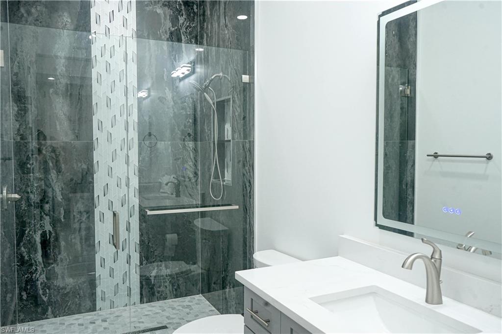 Undisclosed Address Naples, FL 34117 - Photo 19 of 23 a bathroom with a sink and mirror