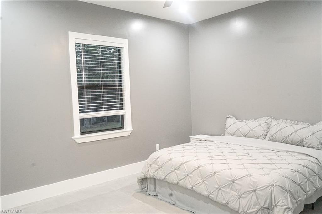 Undisclosed Address Naples, FL 34117 - Photo 21 of 23 a large white bed sitting in a bedroom next to a window