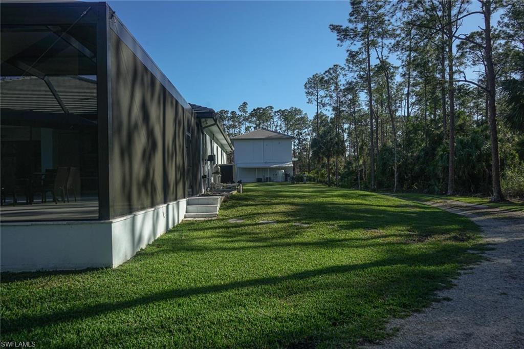 Undisclosed Address Naples, FL 34117 - Photo 9 of 23 a view of a house with a big yard and a large trees