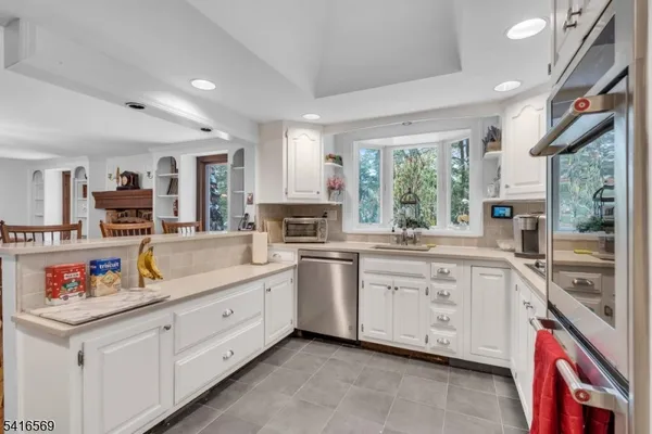 a kitchen with granite countertop white cabinets and white appliances
