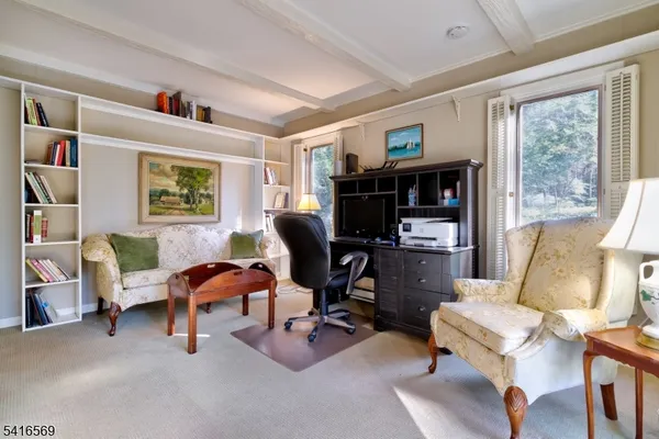 a view of a livingroom with workspace and a window