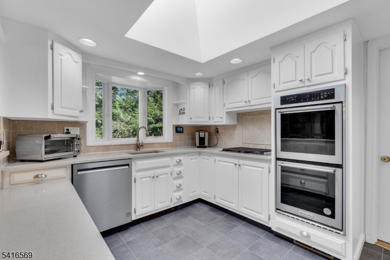 149 Lake End Road Newfoundland, NJ 07435 - Photo 14 of 49 a kitchen with granite countertop white cabinets stainless steel appliances and a window