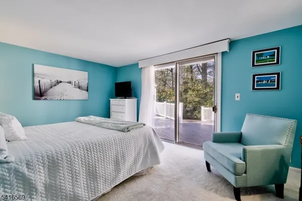 a bedroom with a large bed couch and a large window